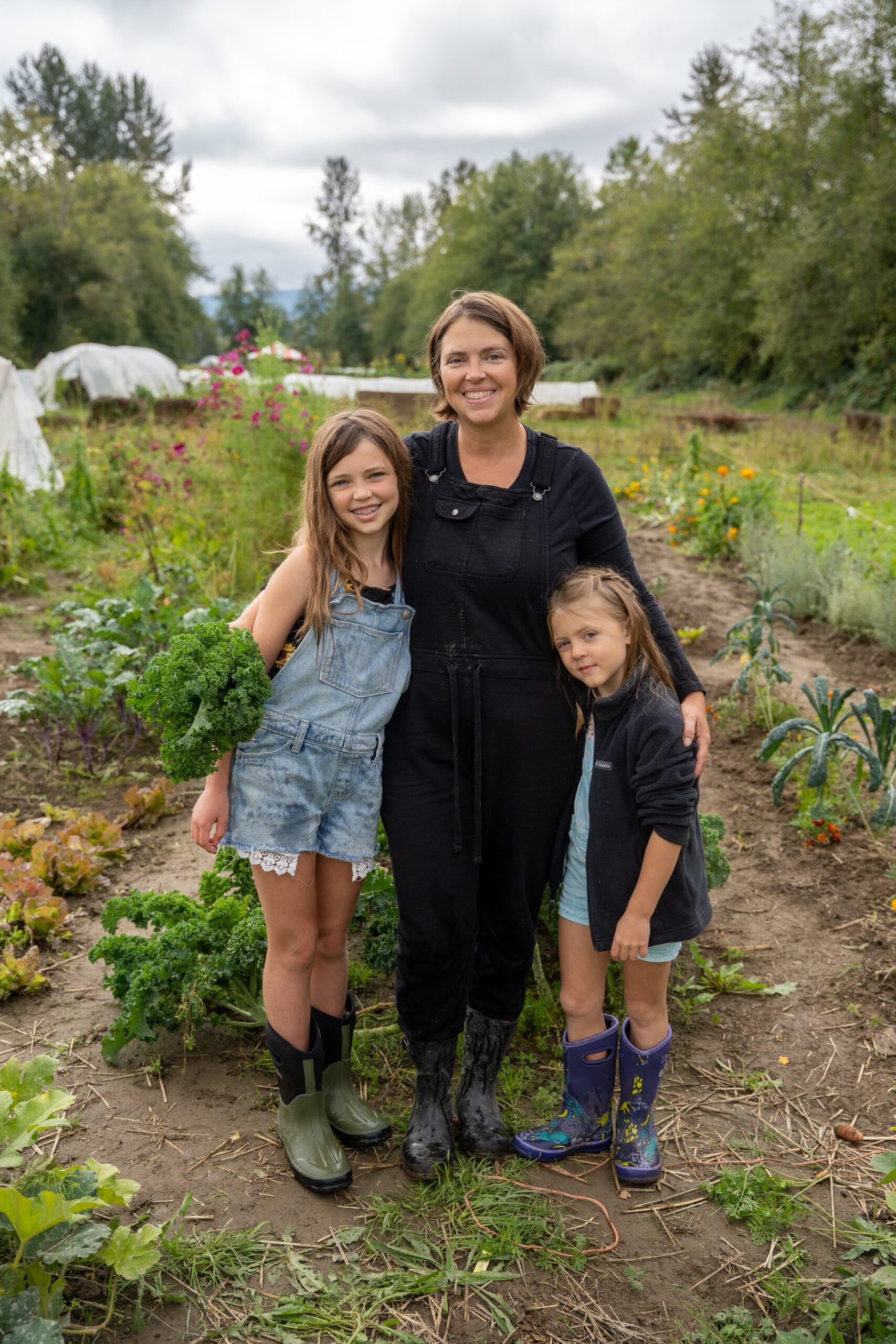Photo of Dana, the farm owner, and her two daughters in their home garden
